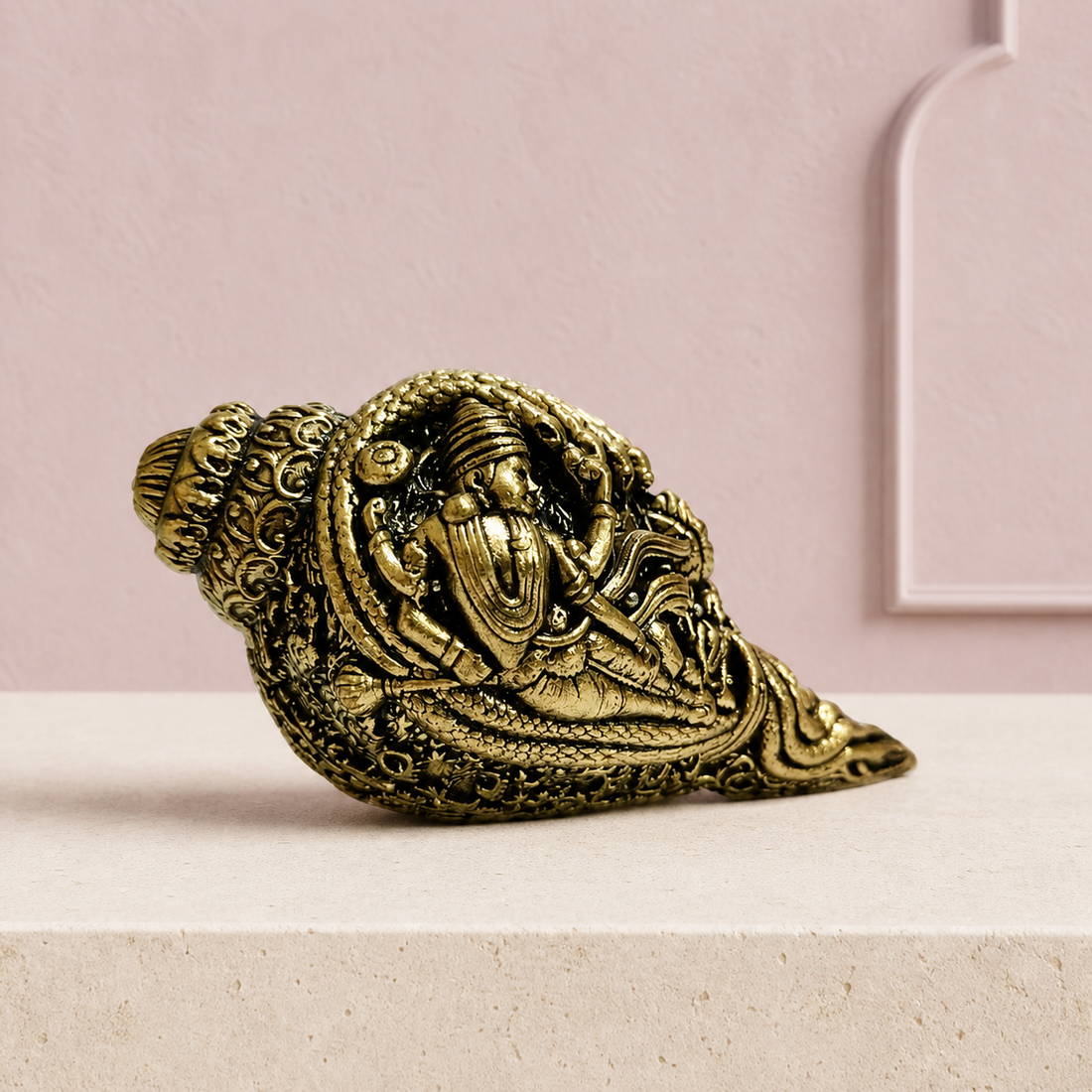 Decorative brass conch with devotional motifs on an ivory platform