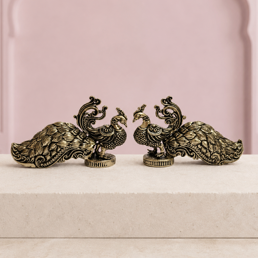 Decorative Brass Peacock Pair on an ivory platform with a soft mauve heritage backdrop