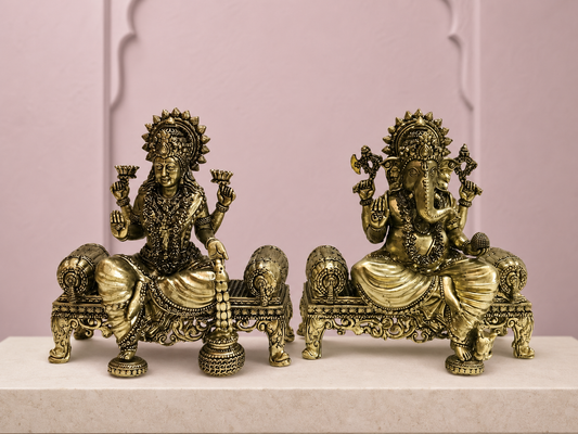 Lakshmi Ganesha Brass Idol Pair on Thrones on an ivory platform with a soft mauve heritage backdrop