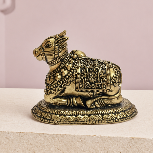 Nandi Brass Idol on an ivory platform with a soft mauve heritage backdrop