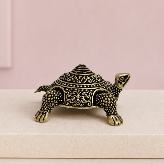 Vastu Tortoise Brass Box on an ivory platform with a soft mauve heritage backdrop